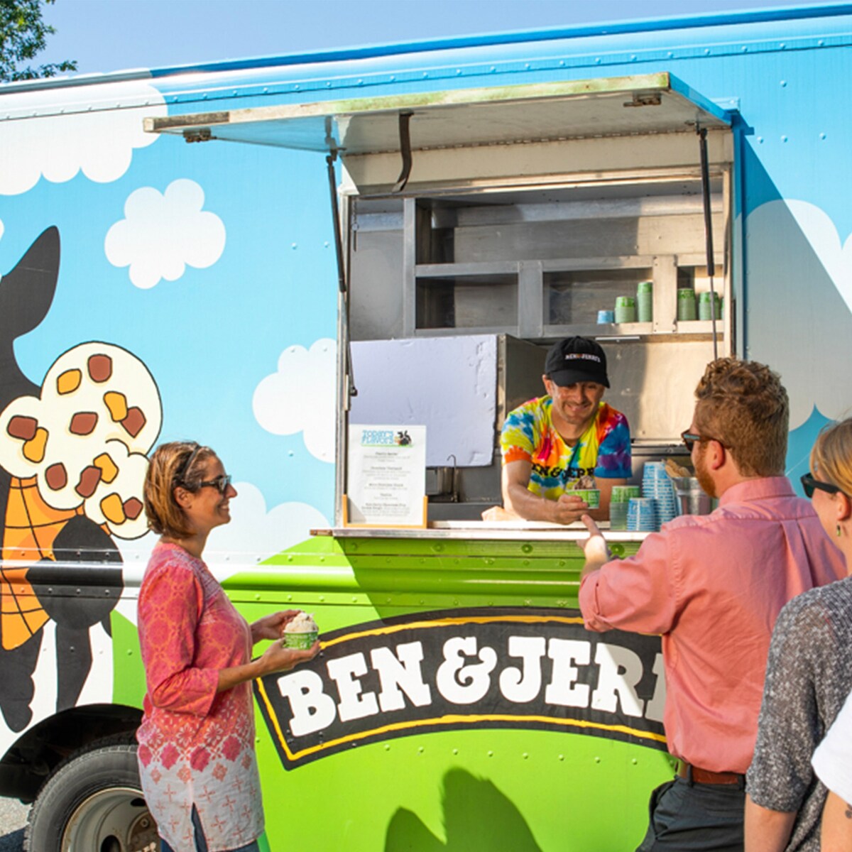 People standing in front of an ice cream catering truck